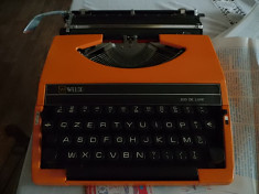 masina de scris portocalie foto