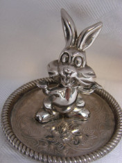 Piesa decorativa din metal argintat, iepuras pe farfurioara foto