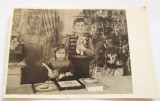 Fotografie veche de familie, alb-negru, Craciun, copii cu jucarii si brad