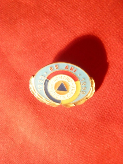 Insigna 65 Ani- Protectia Civila (paramilitara) ,metal si email ,L= 2,6 cm