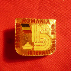 Insigna Targul International Bucuresti , L= 2,3 cm ,lb.engleza , metal si email
