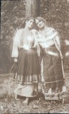 Fotografie tip Carte Postala, Doua tinrtr in costume traditionale, perioada interbelica