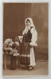 FETITA IN COSTUM POPULAR LANGA UN VAS CU TRANDAFIRI , IN STUDIO , FOTOGRAFIE FORMAT CARTE POSTALA , PERIOADA INTERBELICA