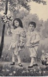 Portret de copii pozand cu o jucarie de tras si un buchet de flori albe langa