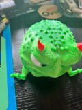 Figurină decorativă &icirc;n formă de broscuță morocănoasă, cu expresie foarte simpatică și multe detalii pe suprafață.
