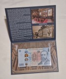 100 Lei 2026, bancnota comemorativa BNR, neatinsa, in pliant, alaturi de plic