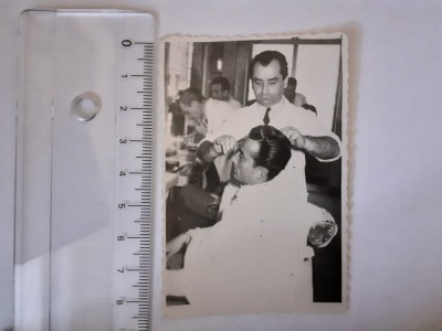 Fotografie cu un frizer tunz&amp;acirc;nd un client foto