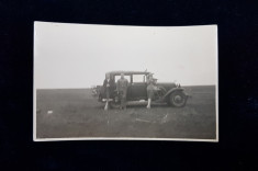 DOUA TINERE SI SOFERUL , POZAND LANGA O MASINA DE EPOCA , IN CAMP , FOTOGRAFIE TIP CARTE POSTALA , MONOCROMA, DATATA 1928 foto