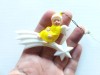 Ornament de Crăciun vintage Germany anii 50-60, &icirc;n formă de &icirc;nger &icirc;ntr-o robă galbena, așezat pe o stea căzătoare albă, celuloid