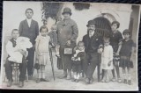 Fotografie tip Carte Postala, Doi adulti cu noua copii, perioada interbelica