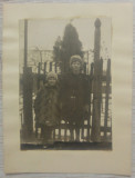Fete in dreptul unui gard dintr-o gospodarie romaneasca, iarna// foto