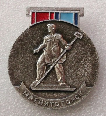 T1 INSIGNA RUSIA URSS MAGNITOGORSK SCULPTURA METALURGIST 1970, 42 x 36 mm ** foto