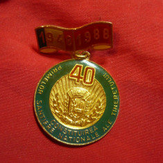 Insigna 40 Ani de la primele Santiere ale Tineretului 1988 ,d=3,3cm ,metal si em
