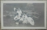 Grup de domnisoare, taran curatind copaci in fundal/ fotografie