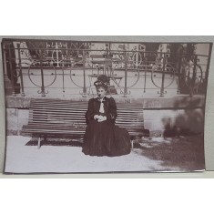 DOAMNA POZAND PE O BANCA , IN PARCUL STATIUNII VITTEL , FRANTA , FOTOGRAFIE MONOCROMA, DATATA PE VERSO 1908