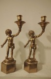Superbă pereche de sfeșnice vintage din bronz aurit care &icirc;nfățișează copii (putti/heruvimi) țin&acirc;nd un suport de lum&acirc;nare.
