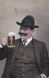Carte postala infatisand un barbat vesel in costum cu vesta, tinand o halba cu