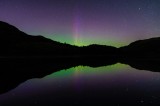 Tablou Canvas, "Aurora boreală oglindită pe lac", Aurora, Reflecție, Stele, Cer, Peisaj, Lumină, Noapte, Natură, Siluete, Mister, Verde, Mov, 39 x 26