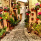 Fototapet de perete autoadeziv si lavabil Strada cu flori din Spello, Umbria, 200 x 150 cm