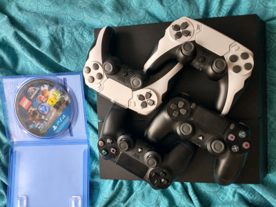 PlayStation 4 cu 4 manete și un joc foto