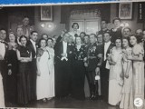 REGALITATE ROMANIA , Distinsi domni si doamne , la o receptie .In spate se vad tablourile cu chipurile regelui FERDINAND si reginei MARIA
