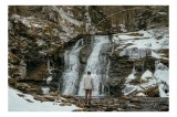 Tablou Canvas, "Om admira cascada &icirc;nzăpezită iarna", Cascadă, Zăpadă, Gheață, Pădure, Roci, Figură Umană, Iarnă, Natură, Tranquilitate, Aventură, 39 x