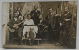 GRUP DE SAPTE MUZICANTI CU INSTRUMENTE SI UN COPIL , FOTOGRAFIE IN INTERIOR , FORMAT CARTE POSTALA , PERIOADA INTERBELICA