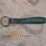 Breloc cu curelusa din silicon , prindere metalica si mesaj in limba engleza