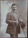 PM508N Bărbat cu baston, pălărie și țigară, studio Naschitz, Lugoj, fotografie mare &ndash; pe spate reclamă Gabor Hecker, magazin de sticlă și de porțelan