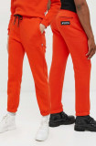 Cumpara ieftin Kangol pantaloni de trening unisex, culoarea portocaliu, neted