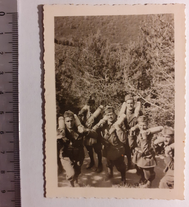Fotografie cu militari căr&acirc;nd niște obuze