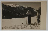 PREDEAL , VEDERE SPRE MUNTI , IN PLAN APROPIAT DOI TINERI PE SCHIURI , FOTOGRAFIE FORMAT CARTE POSTALA , PERIOADA INTERBELICA
