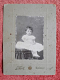 Fotografie tip CDV, fetita stand pe scaun, inceput de secol XX