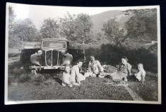 FAMILIE LA IARBA VERDE , POZAND LANGA UN AUTOMOBIL , FOTOGRAFIE TIP CARTE POSTALA , MONOCROMA, PE HARTIE LUCIOASA , DATATA 1940 foto