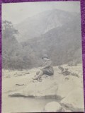 Fotografie, barbat pe malul uni parau, la munte, perioada interbelica