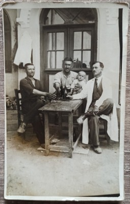 Barbati band bere la o terasa, unul cu copil in brate// foto tip CP foto