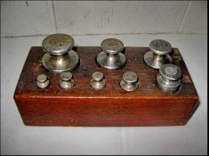 9263-Set Greutati metal in cutie lemn. Continand: 1 greutate de 200 grame+2-100 grame, 1 de 50, 1 de 20, 2 de 10 si 1 de 5 grame.