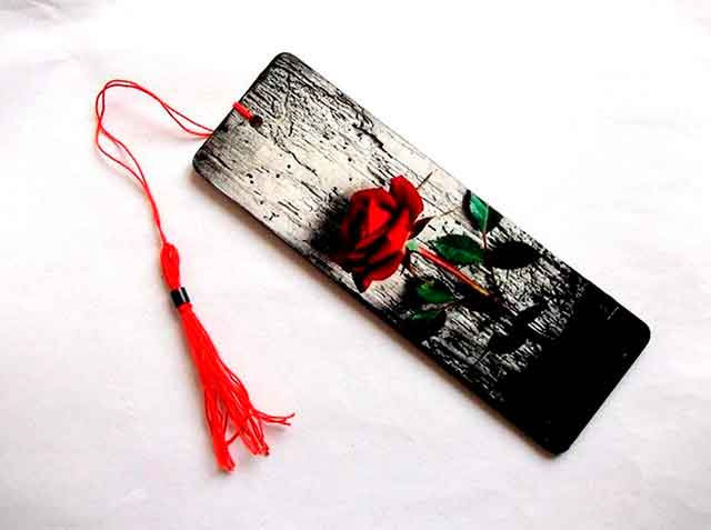 Trandafir rosu pe fundal negru si gri, semn de carte pe lemn 35047