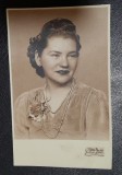 Fotografie tip carte postala, necirculata, tanara cu brosa si margele, perioada interbelica