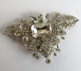 Accesoriu metalic cu pietre din sticla de culoare argintie pentru rochii genti rochie Cristallini, perfect pentru a completa o ținută eleganta