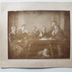 Fotografie veche barbati la masa beind bere, caine sub masa, inceput anii 1900