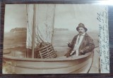 Fotografie tip carte postala de atelier - om in barca de pescuit