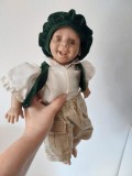 Papusa expresiva realista baiat cu basca si vestuta verde de catifea, plastic si corp de texil umplut, 40cm