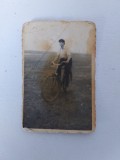 Fotografie cu barbat pe bicicleta, in camp, anii 60, 6x9cm