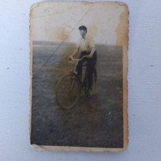 Fotografie cu barbat pe bicicleta, in camp, anii 60, 6x9cm