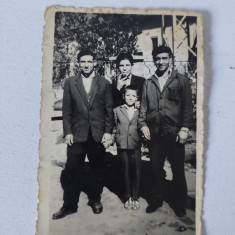 Fotografie cu grup de 3 barbati si 1 copil, intr-o curte, anii 60, 6x9cm