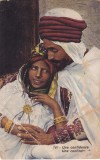Portret romantic cu un barbat in turban rosu si o femeie cu bijuterii mari de