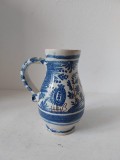 Carafa ceramica / cana cu toarta, veche, vintage, facuta manual, pictata cu albastru motive stilizate din natura si cu maro inchis un strut, 14cm