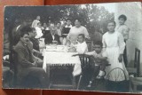 Fotografie tip carte postala, familie la masa, perioada interbelica