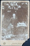Fotografie tip CDV, Barbat la masa (Nae Andreescu comerciant), in gradina, inceput de secol XX